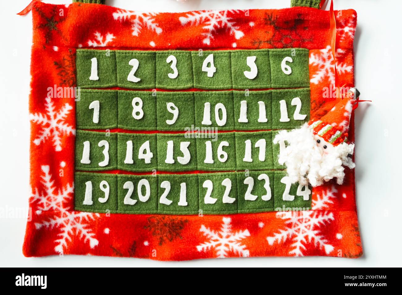 Adventskalender mit Weihnachtsmann aus rotem, grünem und weißem Filzstoff zum Abzählen auf Weihnachten, weißer Hintergrund Stockfoto