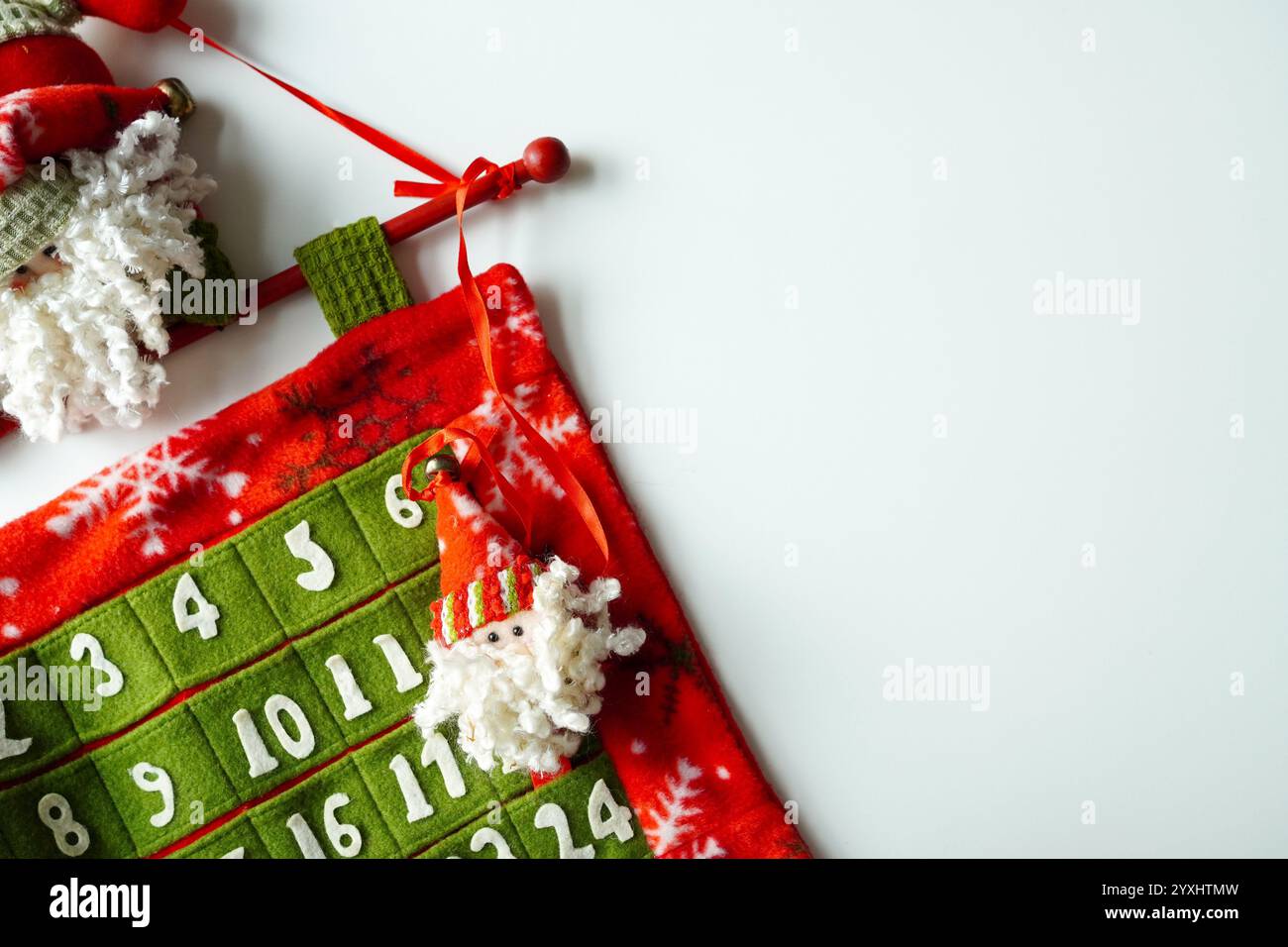 Adventskalender mit Weihnachtsmann aus rotem, grünem und weißem Filzstoff zum Abzählen auf Weihnachten, weißer Hintergrund Stockfoto