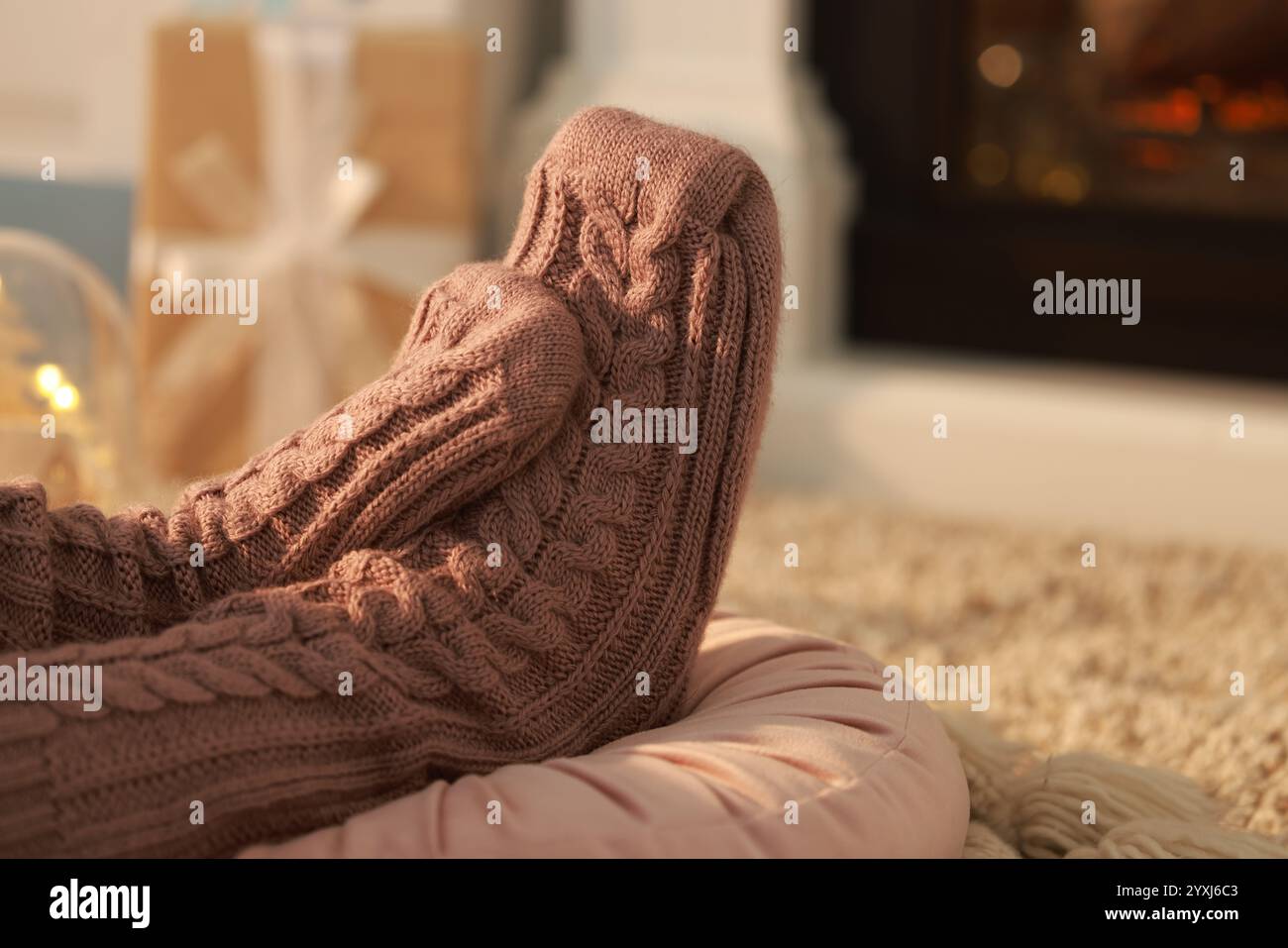 Frau in gestrickten Socken, die zu Hause ruht, Nahaufnahme. Leerzeichen für Text Stockfoto