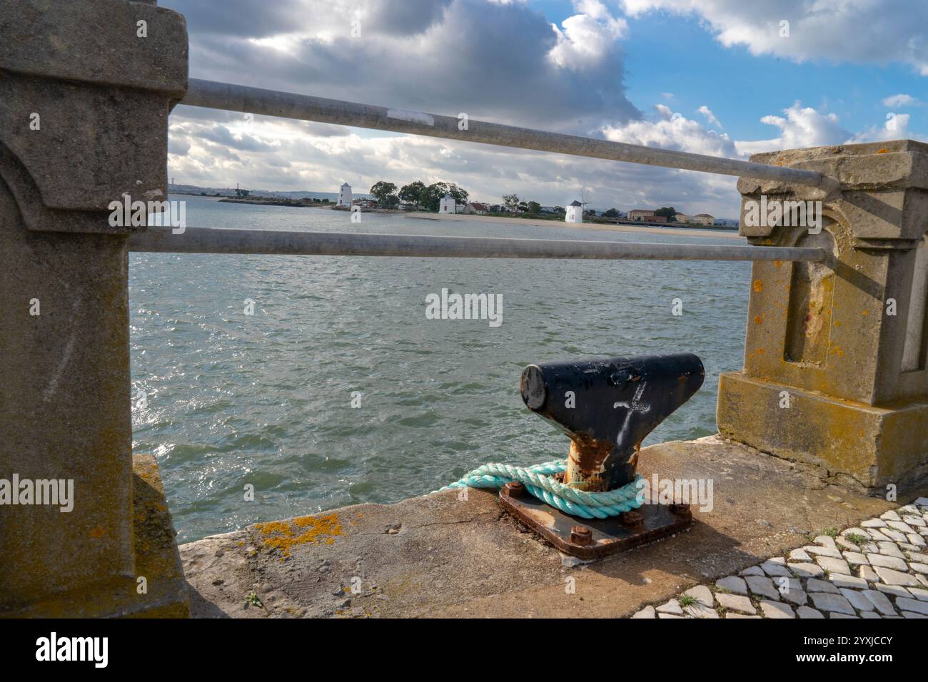 3 Alburrica-Windmühlen in Barreiro mit alter Mauer im Vordergrund 2 horizontale Eisenstangen und Bootsanker Stockfoto