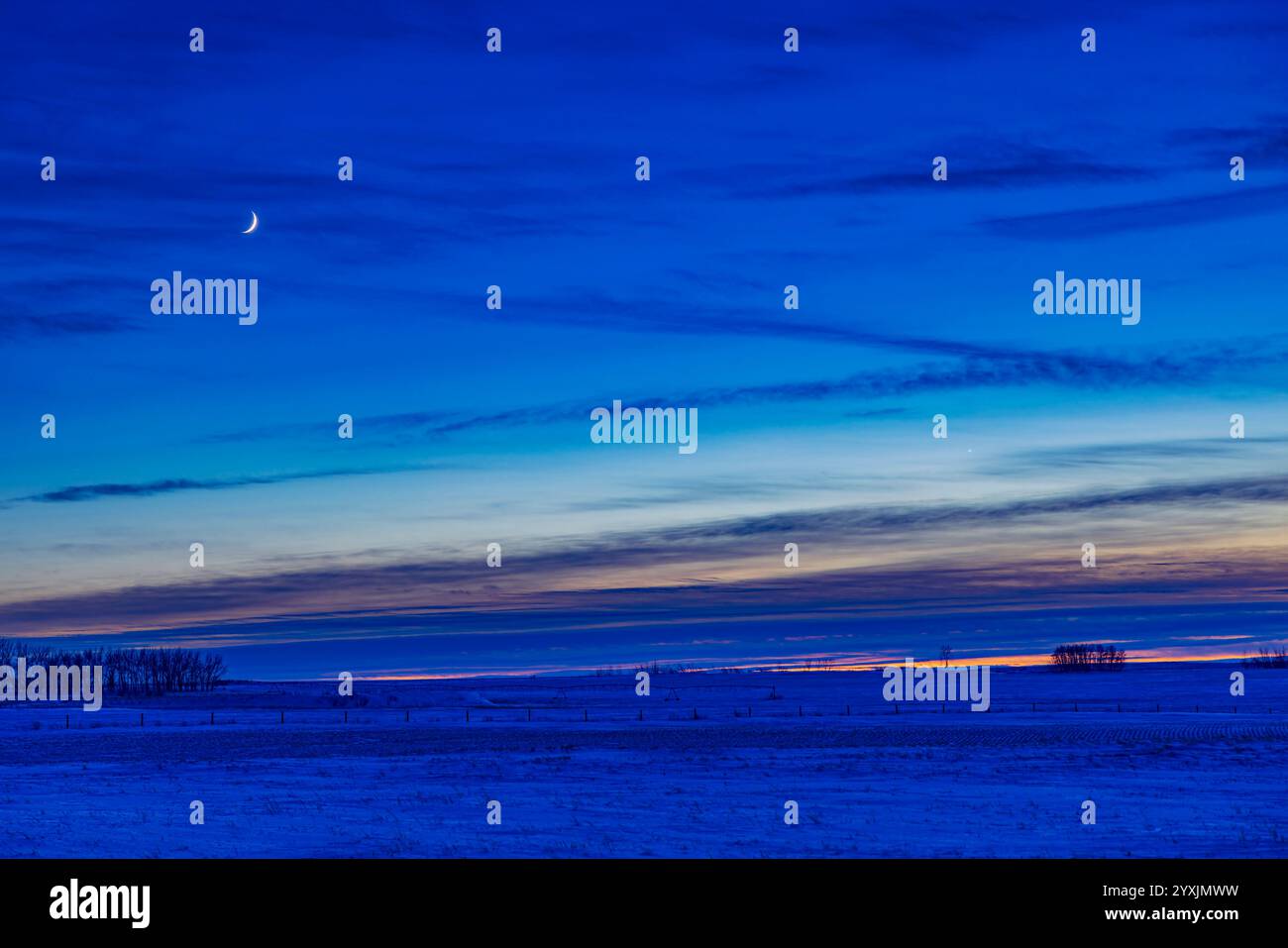 Der wachsende Halbmond über der Paarung von Quecksilber und Venus in der Abenddämmerung. Stockfoto