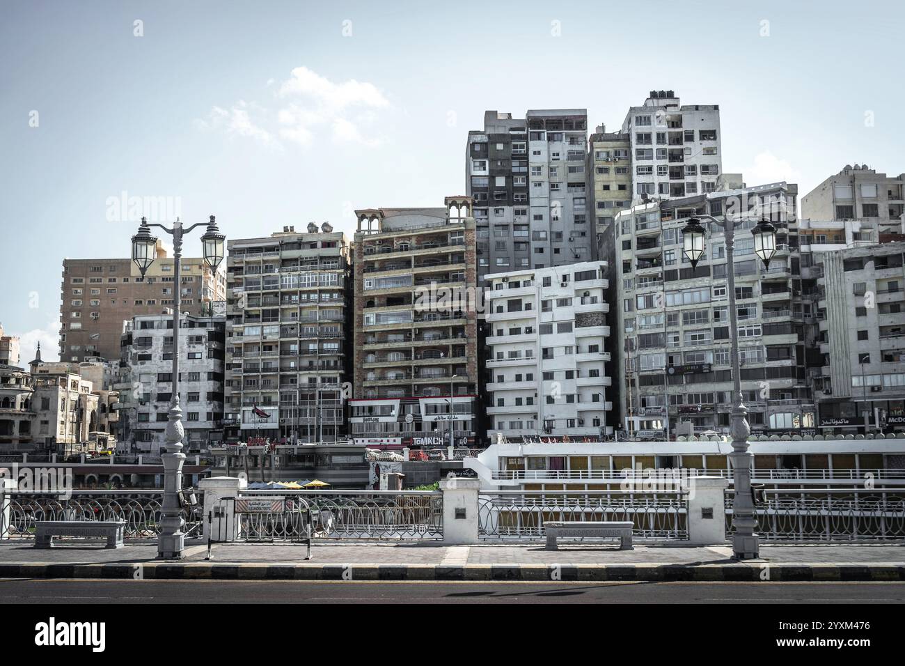 Die Corniche in Alexandria, Ägypten, besticht durch eine Reihe dicht gepackter, veralteter Wohnhäuser, die eine Mischung aus urbanem Verfall und architektonischem Charme darstellen. Stockfoto