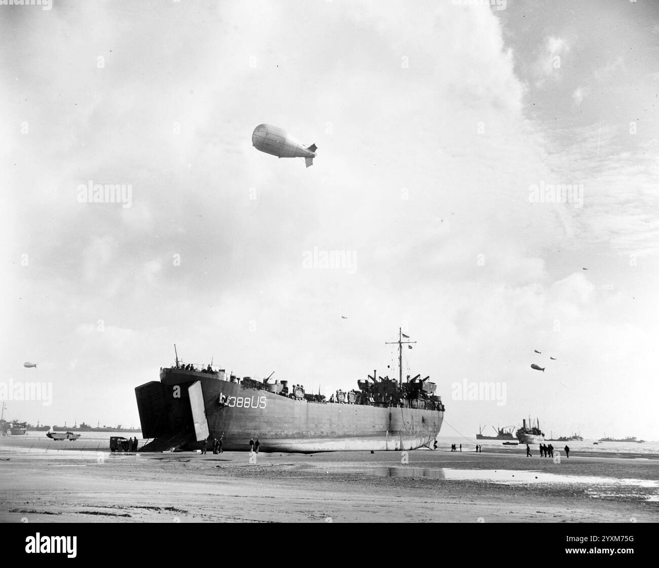 USS LST-388 entlädt an einem Strand der Normandie bei Ebbe, 12. Juni 1944. Beachten Sie, dass der Ballon über dem Luftballon liegt. Aufgenommen von Combat Photo Unit 8 (CPU-8). Offizielles Foto der US Navy Stockfoto