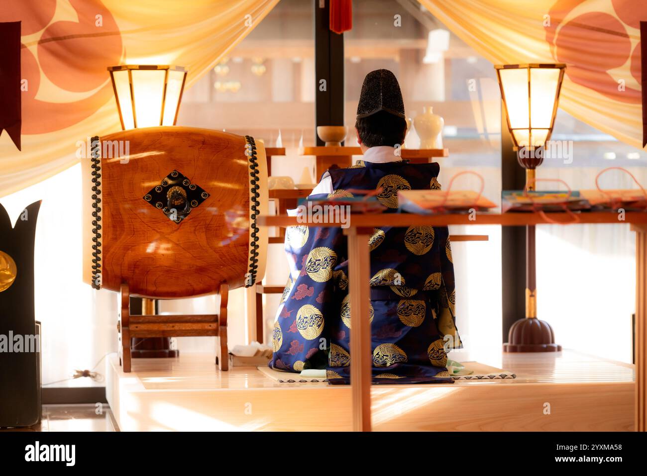 Der schintoistische Priester Kannushi oder Shinshoku trägt einen eboshi-Hut und das Kleid Kariginu kniet zum Gebet nieder Stockfoto
