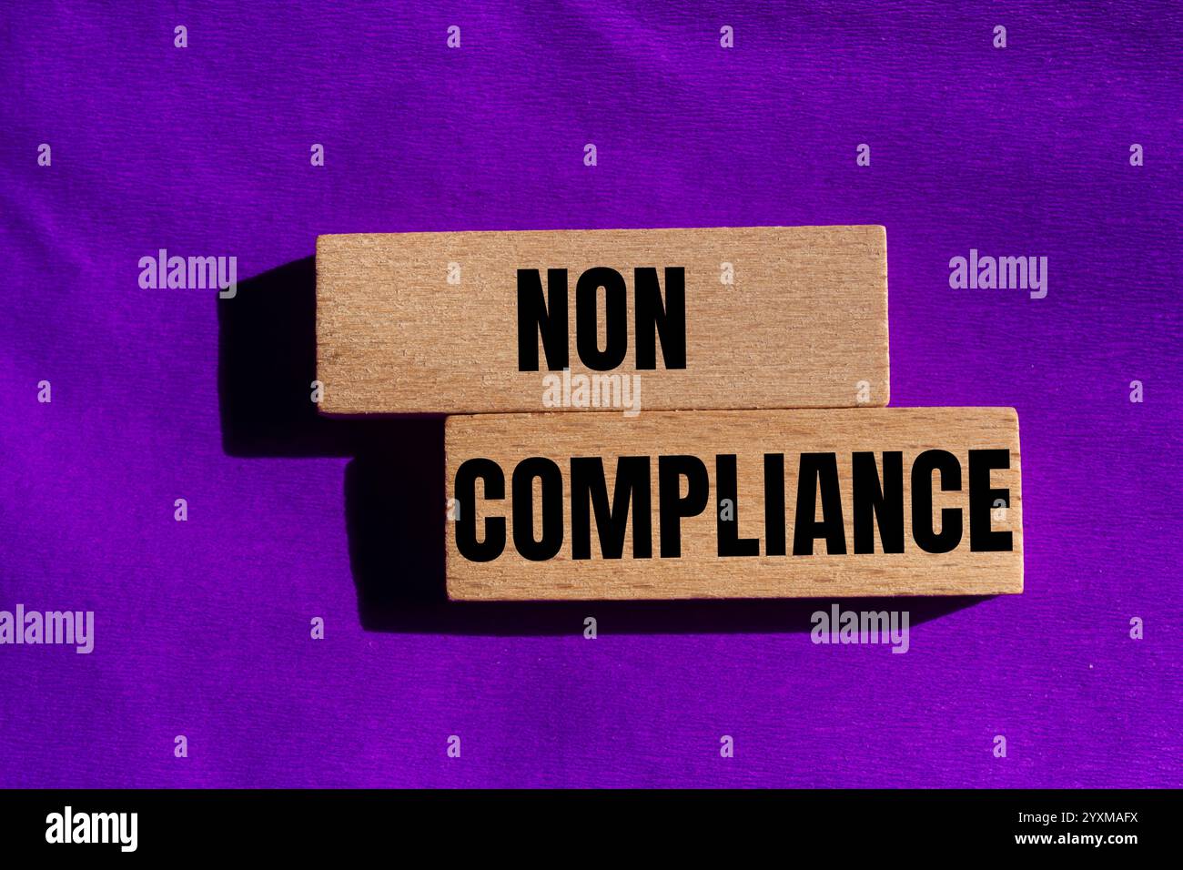 Meldung über Nichteinhaltung auf Holzblöcken mit violettem Hintergrund. Symbol für konzeptionelle Nichteinhaltung. Kopierbereich. Stockfoto
