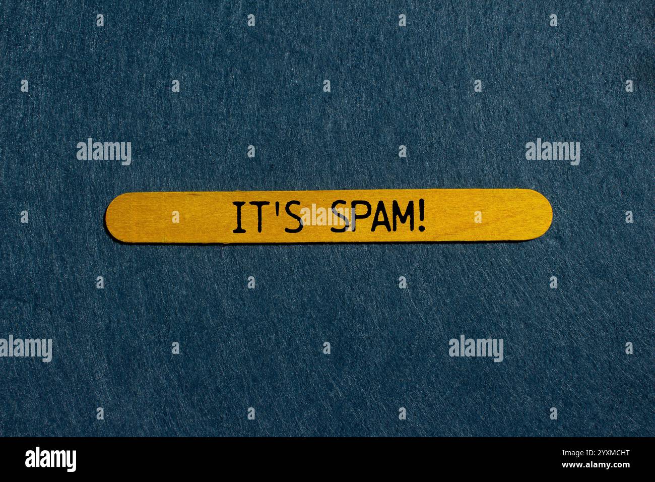 Es ist eine Spam-Nachricht auf gelbem Holzstab mit grauem Hintergrund. Konzeptionell ist das Spam-Symbol. Kopierbereich. Stockfoto