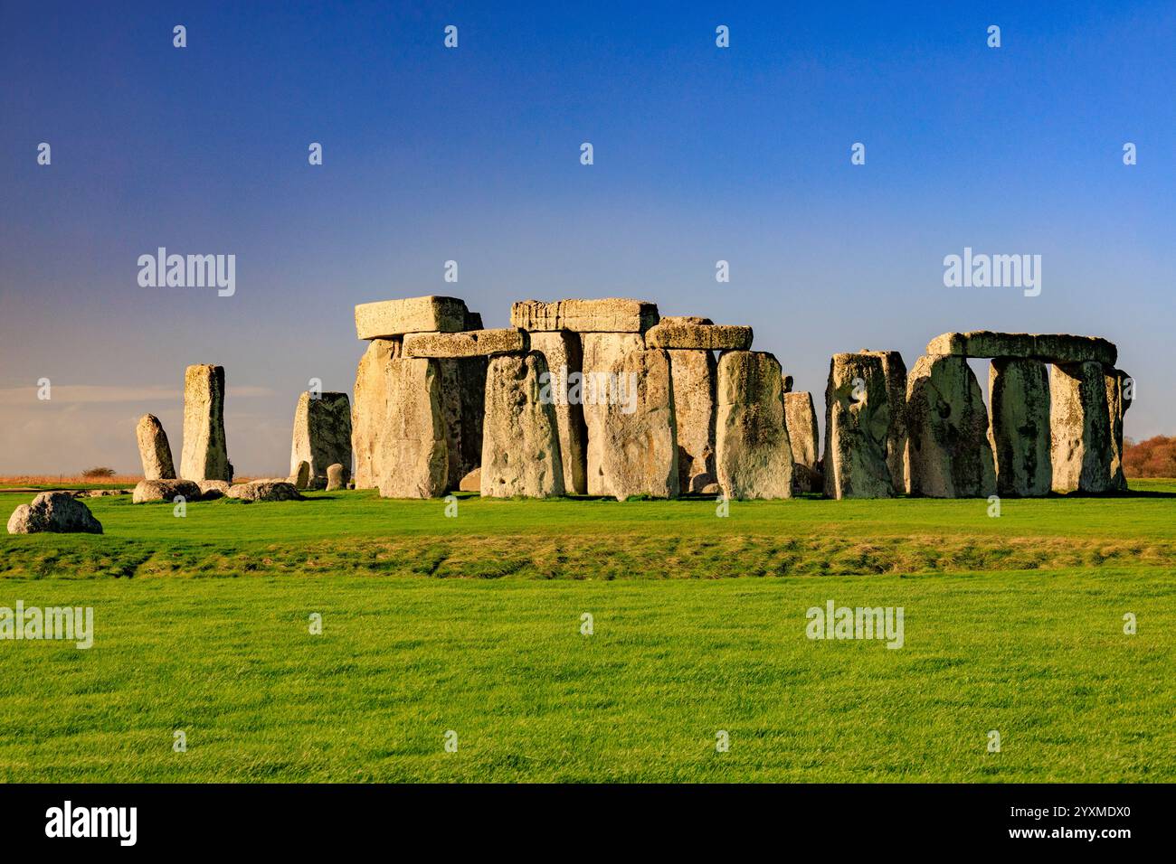 Wintersonne am prähistorischen megalithischen Steinkreis in Stonehenge auf der Salisbury Plain, heute ein geplantes altes Denkmal in Wiltshire, England Stockfoto