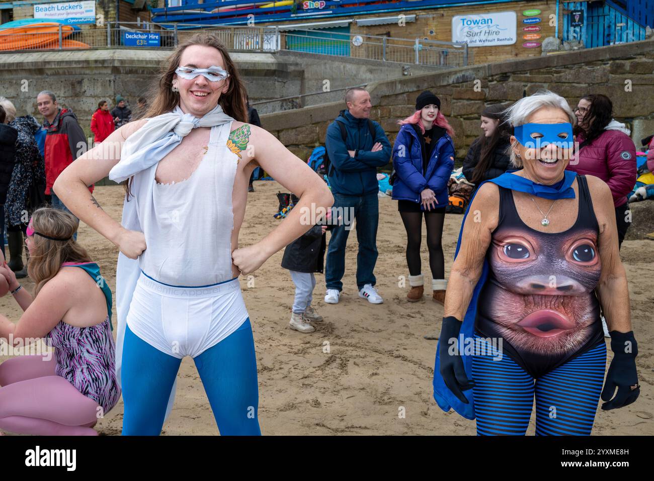 Die Teilnehmer treffen sich am Strand von Towan und bereiten sich auf die jährliche Veranstaltung „Superhero in the Cold“ vor, um Spenden für die britische Krebsforschung zu sammeln. Stockfoto
