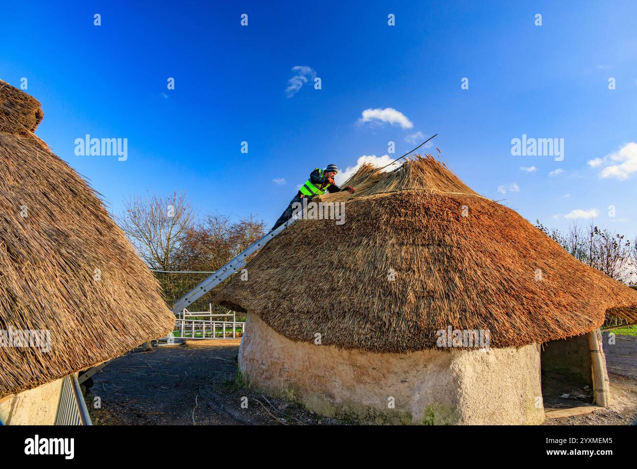 Nachbildungen neolithischer Häuser, die vor dem Stonehenge Besucherzentrum in der Salisbury Plain, einem geplanten antiken Monument, in Wiltshire, England, reetgedeckt werden Stockfoto