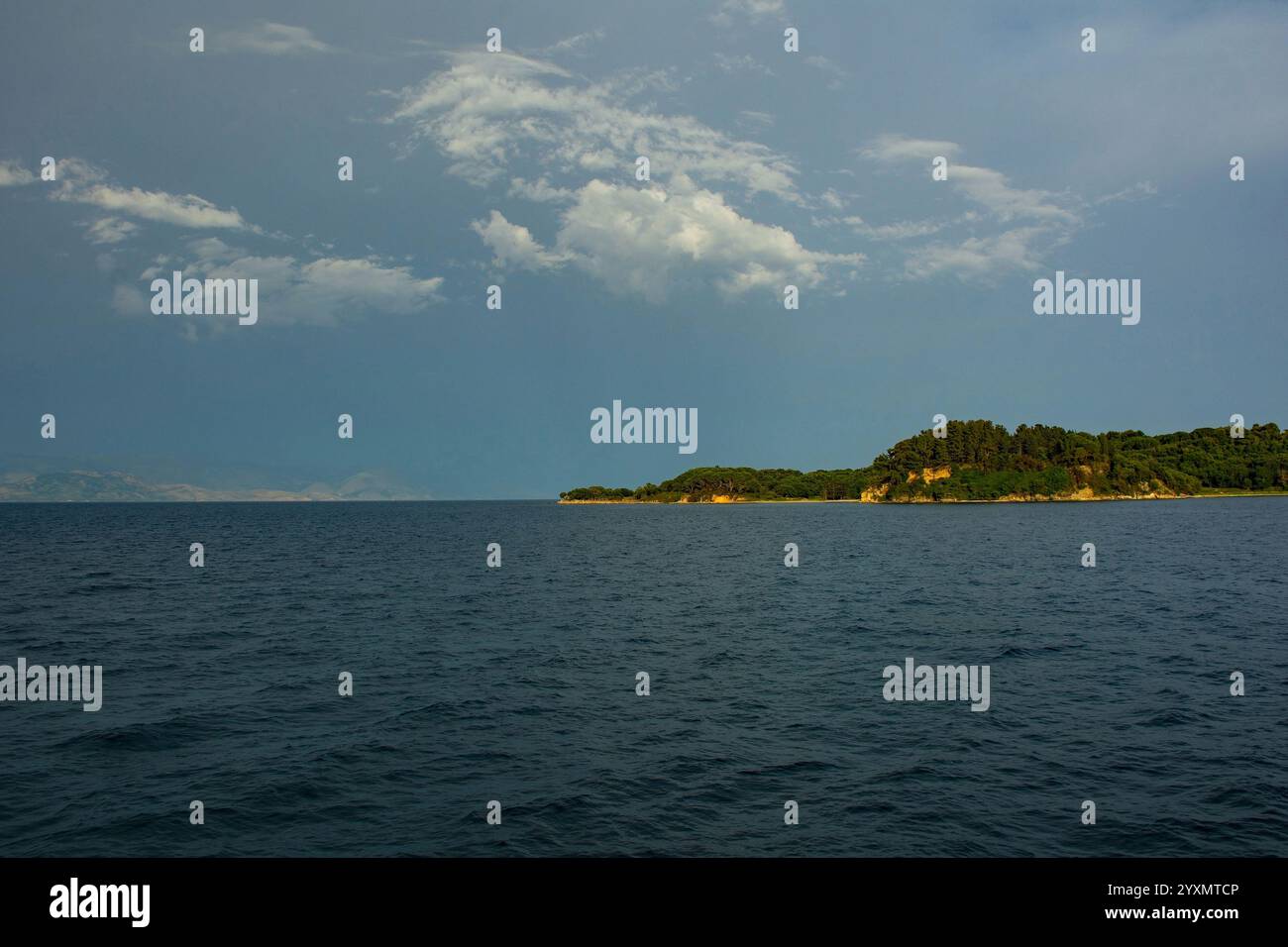 Die griechische Insel Vido in der Straße von Korfu im Ionischen Meer, vor der Küste von Korfu Stadt. Hintergrund - die trübe Küste bis Südalbanien Stockfoto