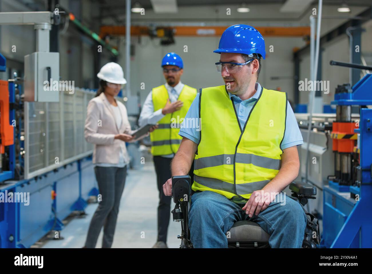 Zwei Mitarbeiter sprechen mit einer Führungskraft und zeigen Fertigungsabläufe und -Pläne auf einem digitalen Tablet. Modernes Industriekonzept. Stockfoto