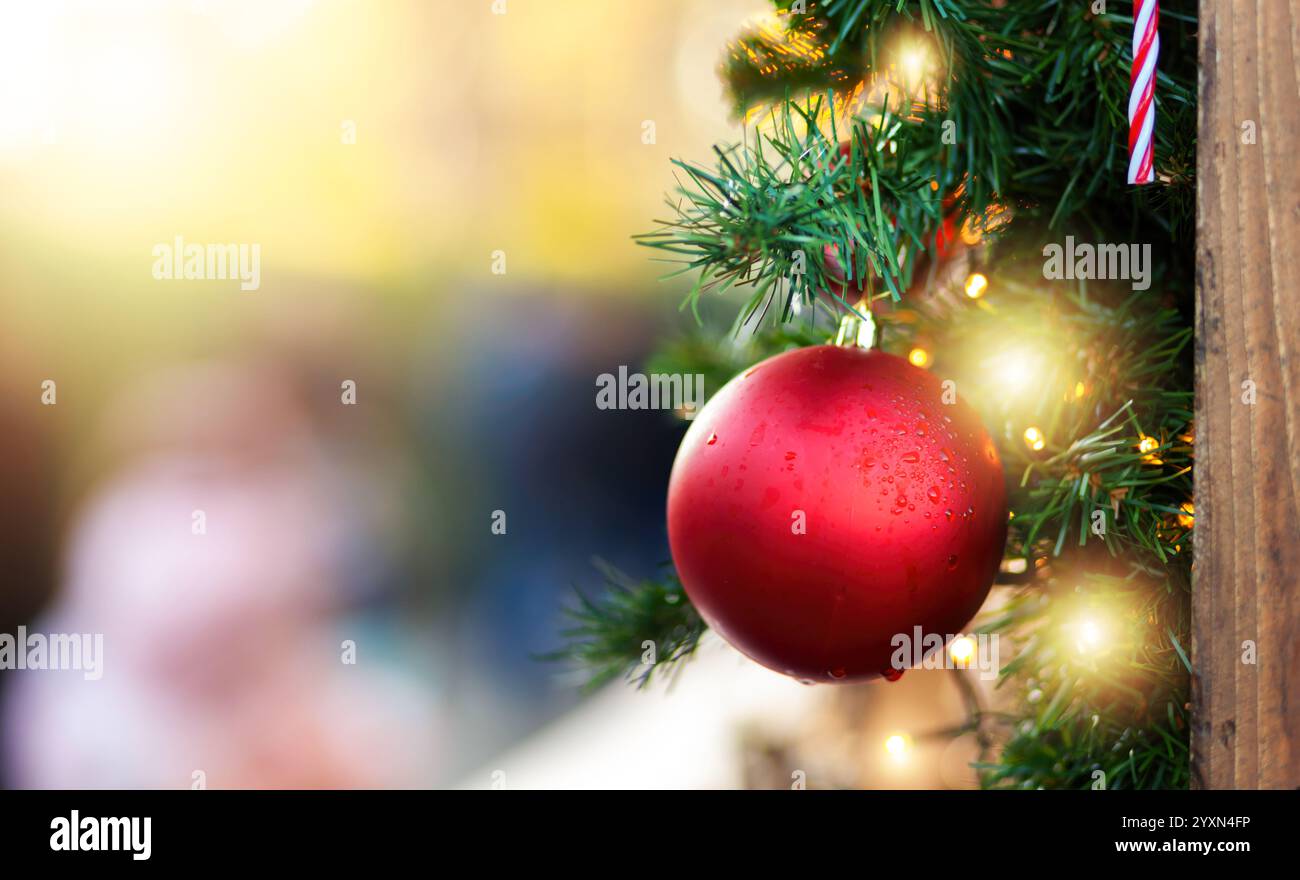 Weihnachtsdekoration mit einem leuchtenden roten Ball, einem festlichen Zuckerrohr und funkelnden Lichtern, die anmutig an einem wunderschön verzierten weihnachtsfest hängen Stockfoto