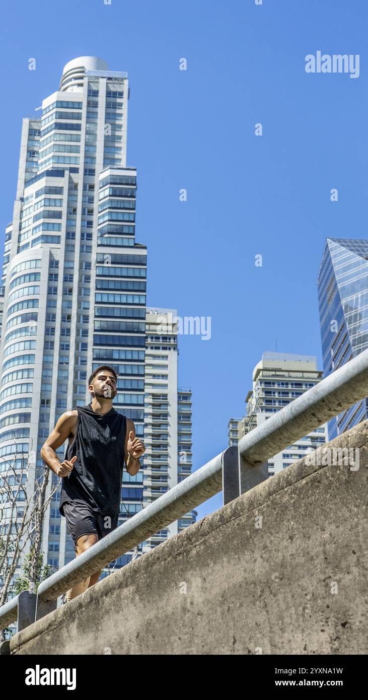 Urbaner Jogger, der durch die Straßen einer Stadt voller hoher Gebäude navigiert. Stockfoto