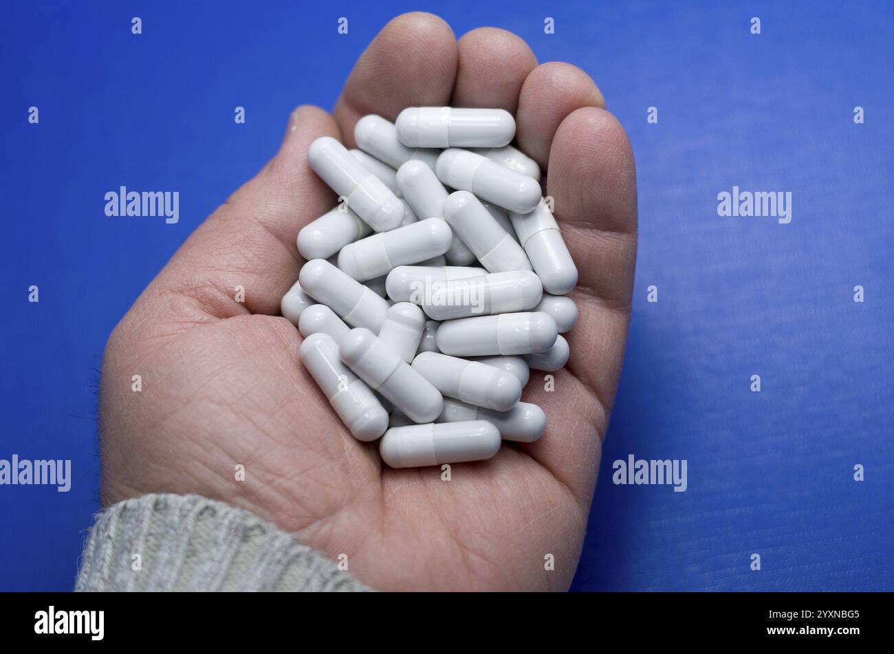 Große weiße Pillen fielen aus einer großen weißen Flasche. Arzneimittelbegriff. Leben ohne Medikamente und Abhängigkeit von Antibiotika-, Medizin-, Amphetamin-Kapseln Stockfoto