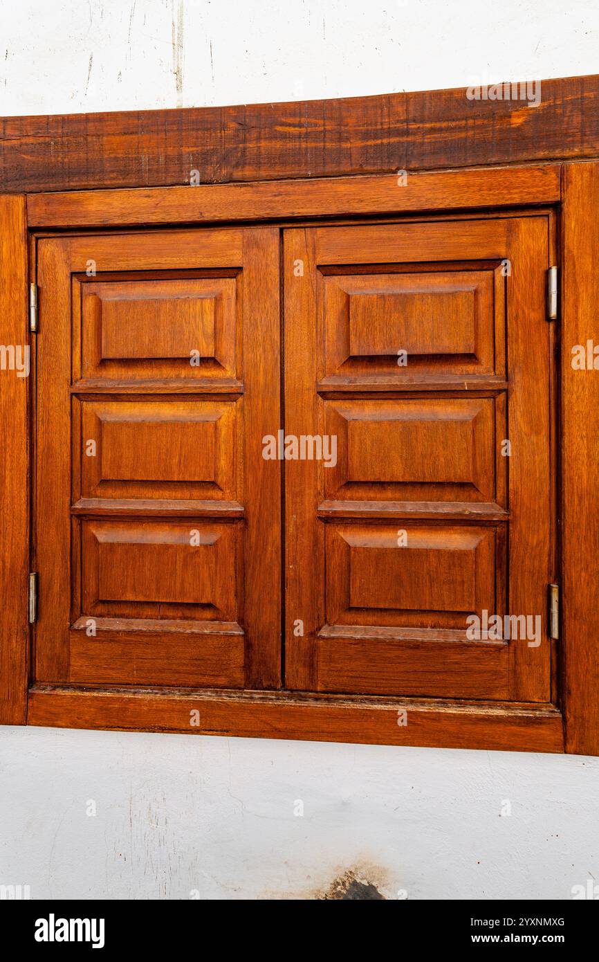 Ein Holzfenster mit weißem Rahmen. Das Fenster ist offen und das Licht scheint durch das Fenster Stockfoto