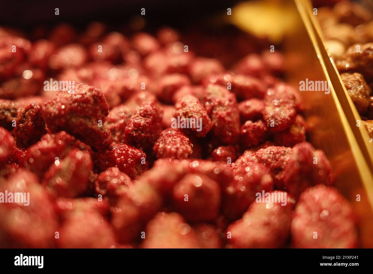 Eine Nahaufnahme eines Haufens roter Nüsse. Die Nüsse sind klein und glänzend, und sie sind so angeordnet, dass sie aussehen, als wären sie übereinander gestapelt Stockfoto