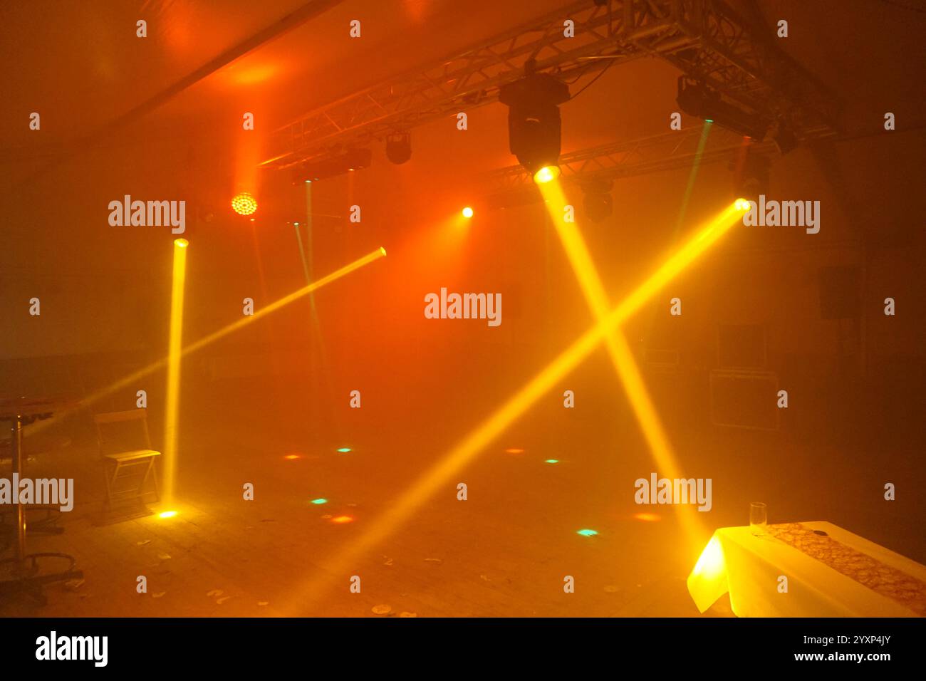 Ein schwach beleuchteter Raum mit einer Bühne und einem Spotlight auf einem Tisch. Die Szene ist geheimnisvoll und faszinierend Stockfoto