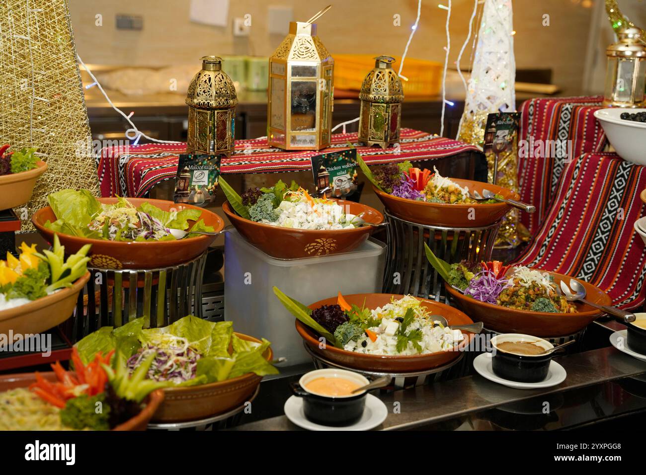 Nahaufnahme aus der Seitenansicht der lebhaften Präsentation frischer Salate und Beilagen, die elegant in rustikalen Schalen angeordnet sind. Stockfoto