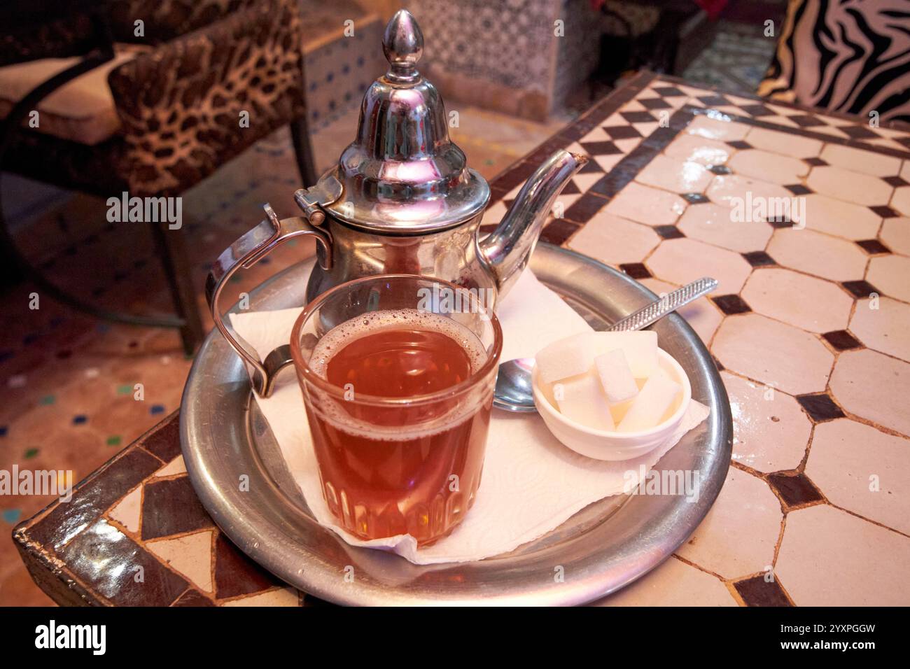 marokkanischer Minztee mit Teekanne und Zucker in einem Riad in marrakesch, marokko Stockfoto