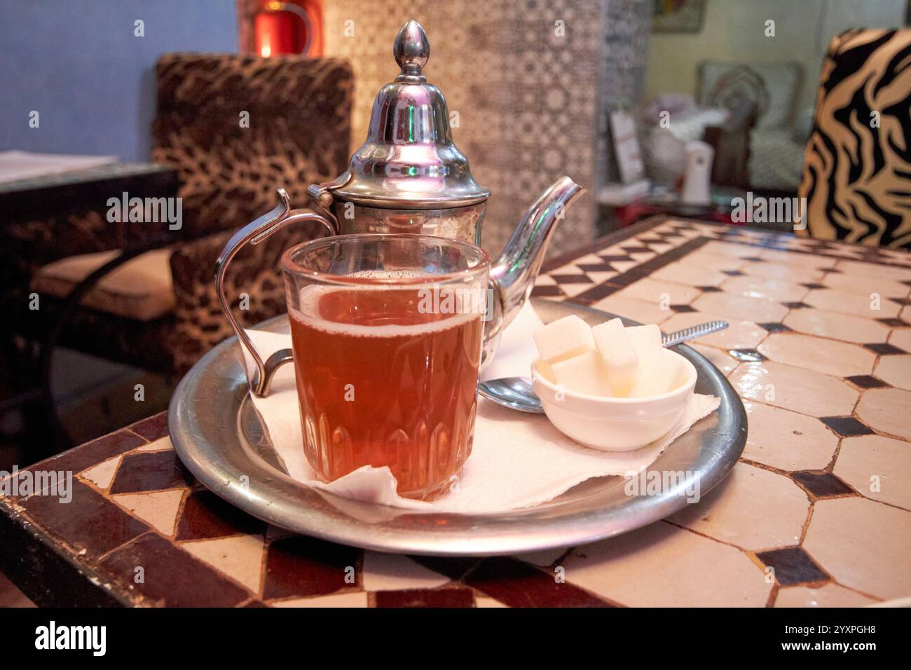 marokkanischer Minztee mit Teekanne und Zucker in einem Riad in marrakesch, marokko Stockfoto