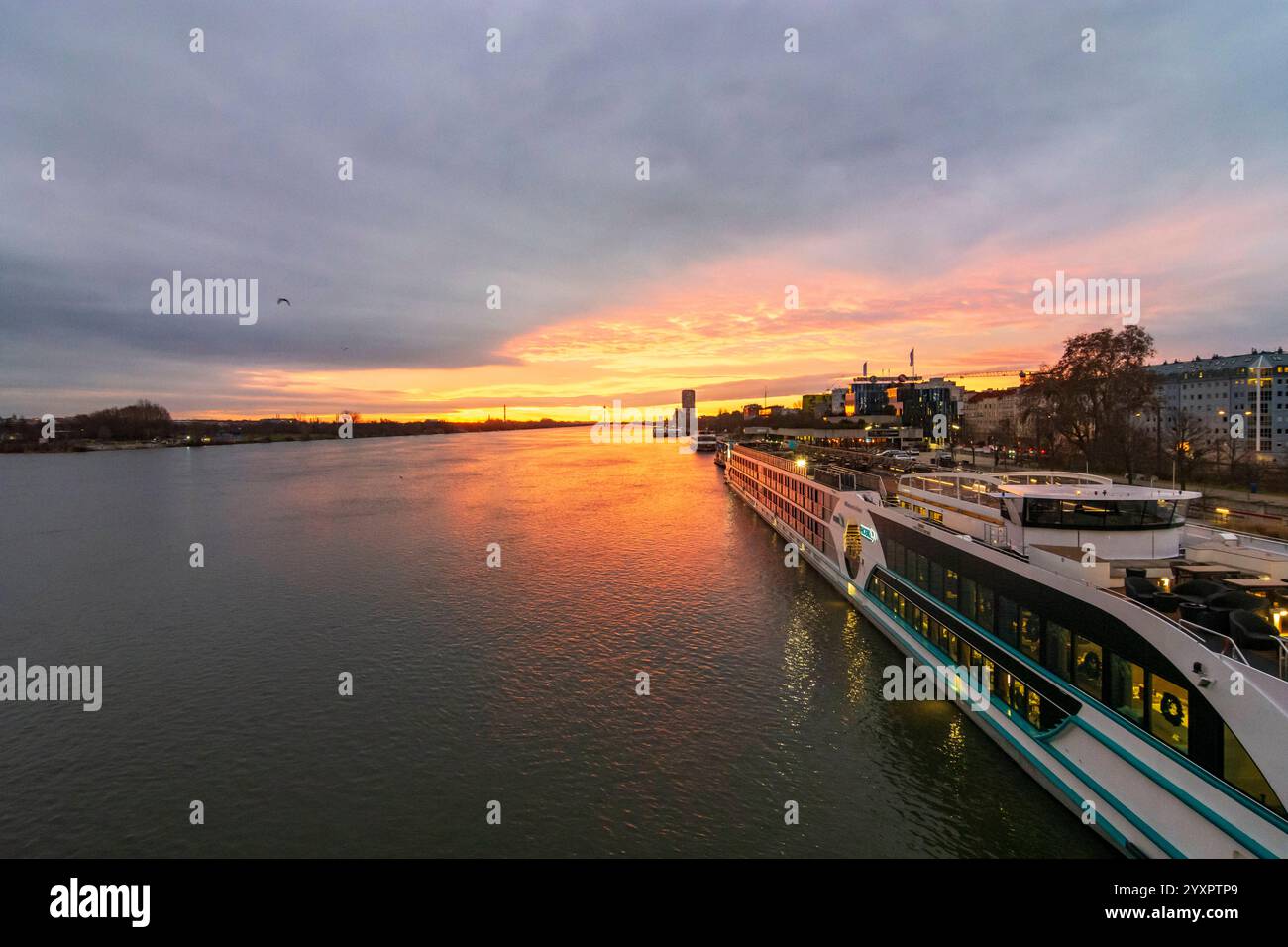 Feuriger Sonnenaufgang an der Donau Donau, Kreuzfahrtschiffe an der Endbrücke Reichsbrücke Wien 02. Leopoldstadt Wien Österreich Stockfoto