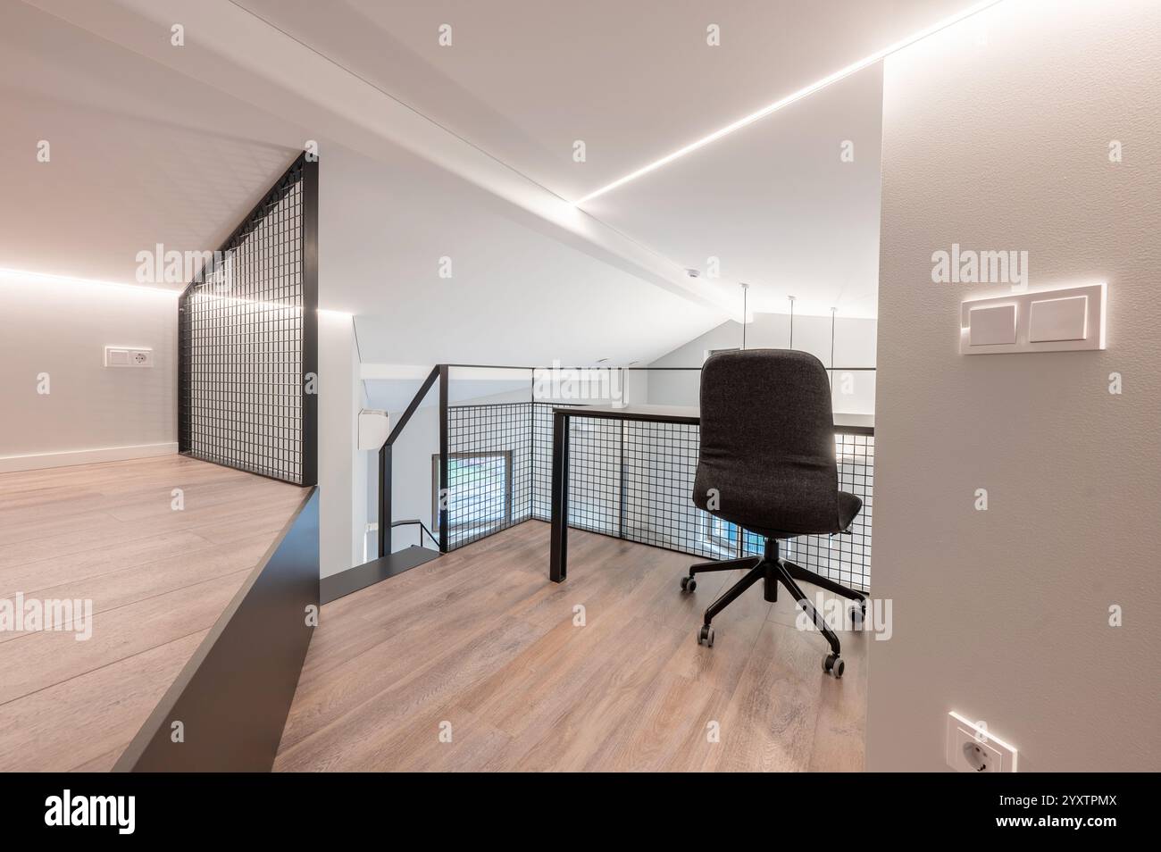 Stilvolles Büro-Loft mit modernem ergonomischem Stuhl, großem Holzboden und schlanken minimalistischen Designelementen, perfekt für kreative Profis Stockfoto
