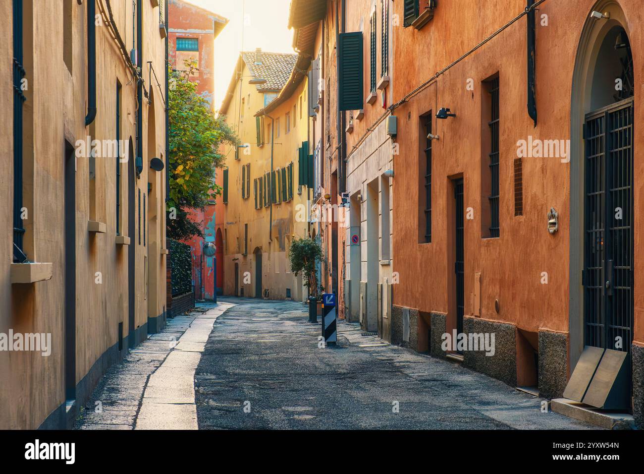 Mittelalterliche enge Straße mit niemandem in der Altstadt von Bologna, Emilia Romagna, Italien bei Sonnenaufgang. Italienische Straße mit farbenfrohen Gebäudefassaden. Reisen Stockfoto