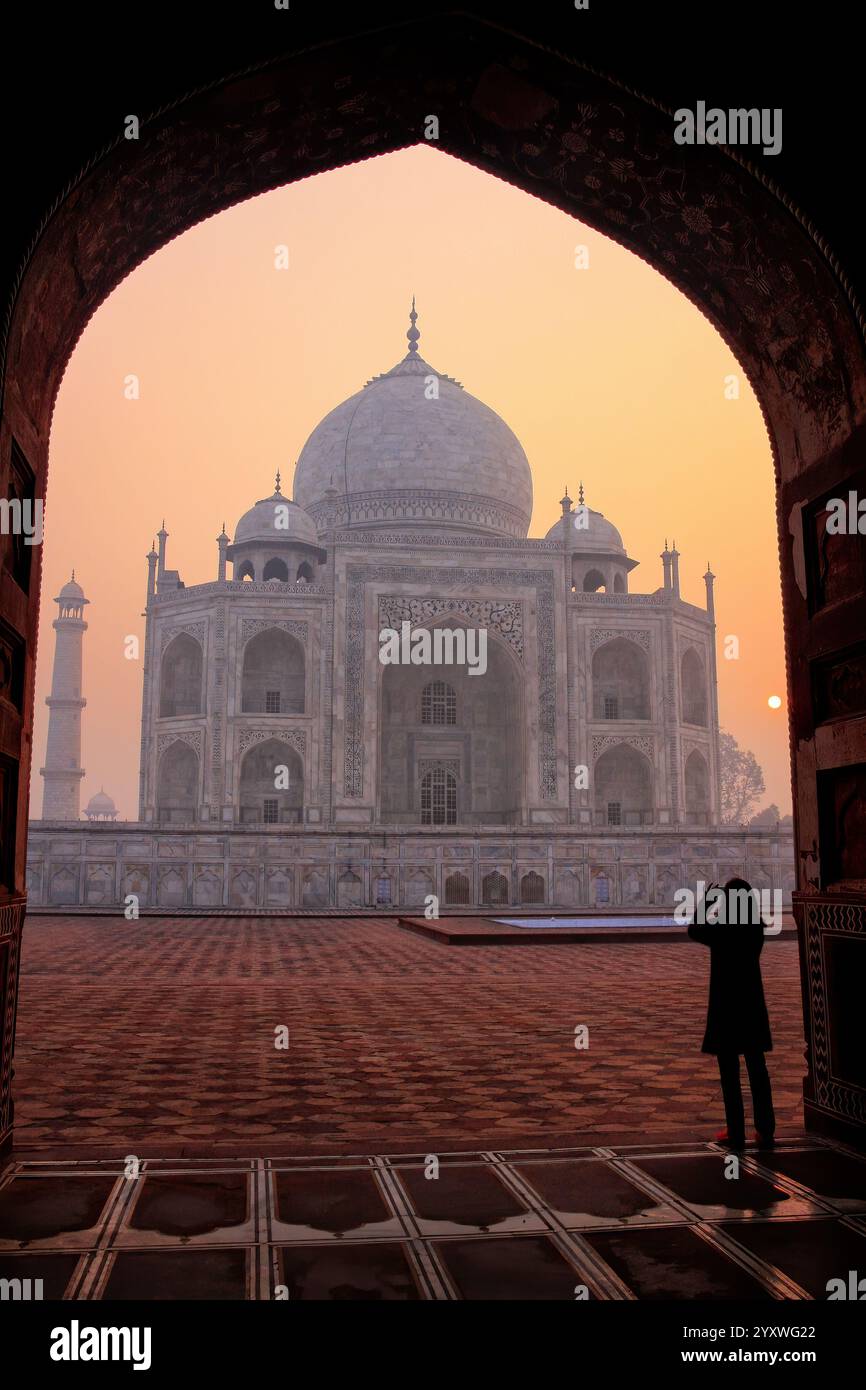 Taj Mahal bei Sonnenaufgang gerahmt mit dem Bogen der Moschee, Agra, Uttar Pradesh, Indien. Taj Mahal wurde 1983 zum UNESCO-Weltkulturerbe erklärt. Stockfoto