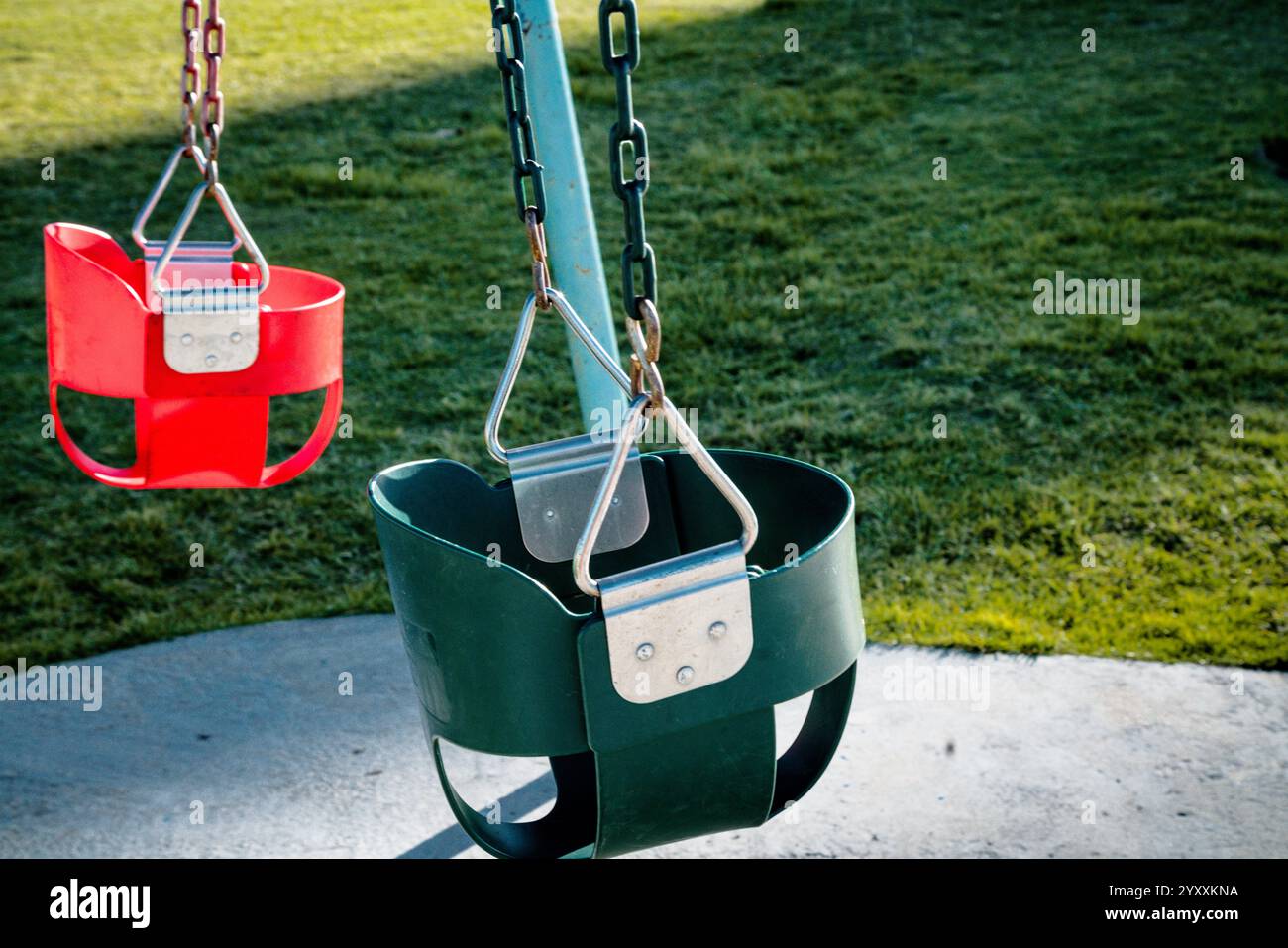 Spielplatz im Park mit zwei bunten Schaukeln ohne Personen. Stockfoto