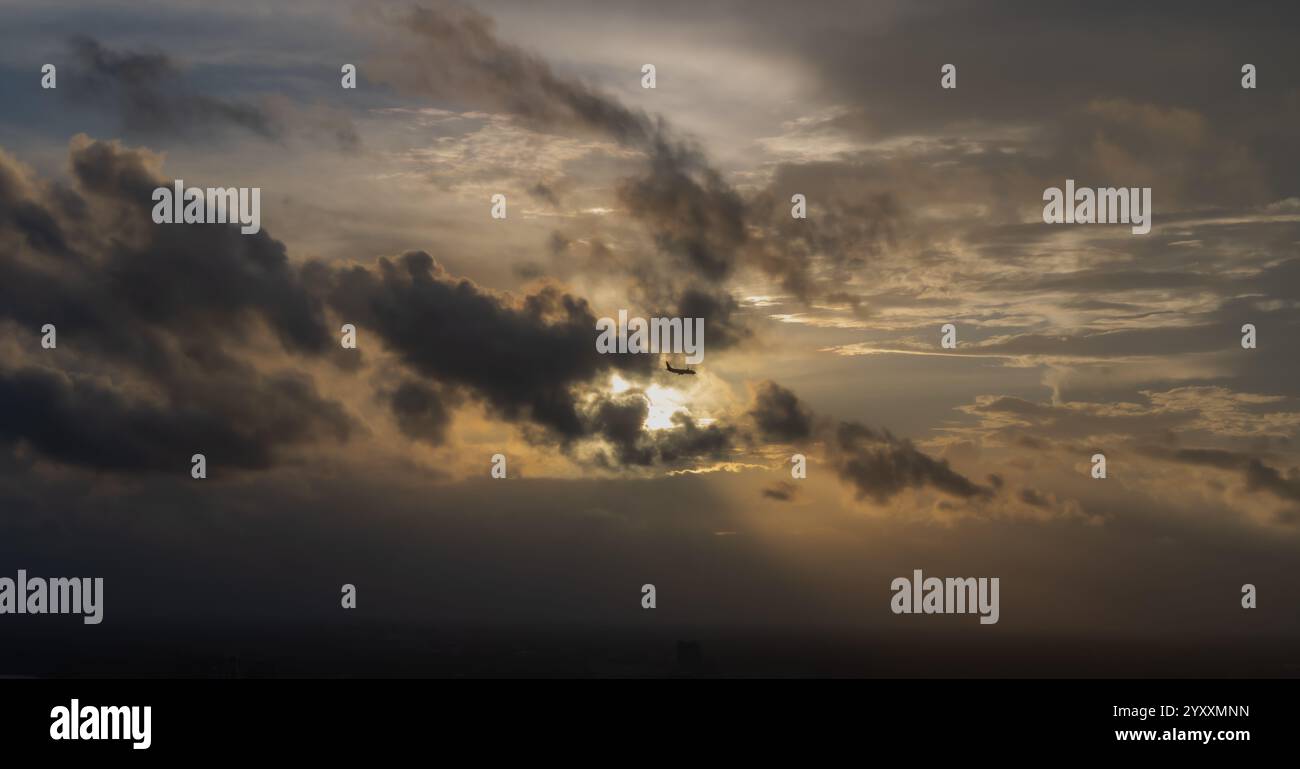 Blick auf einen Sonnenuntergang mit Wolken in Miami Florida mit einem Flugzeug bereit zur Landung. Stockfoto