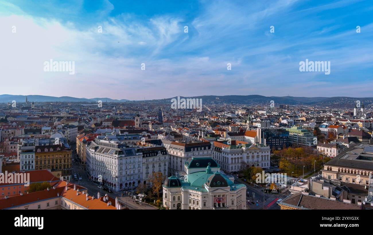 Ein atemberaubender Panoramablick auf das Stadtzentrum Wiens mit seiner historischen Architektur, pulsierenden Dächern und kulturellen Wahrzeichen unter klarem blauen Himmel Stockfoto