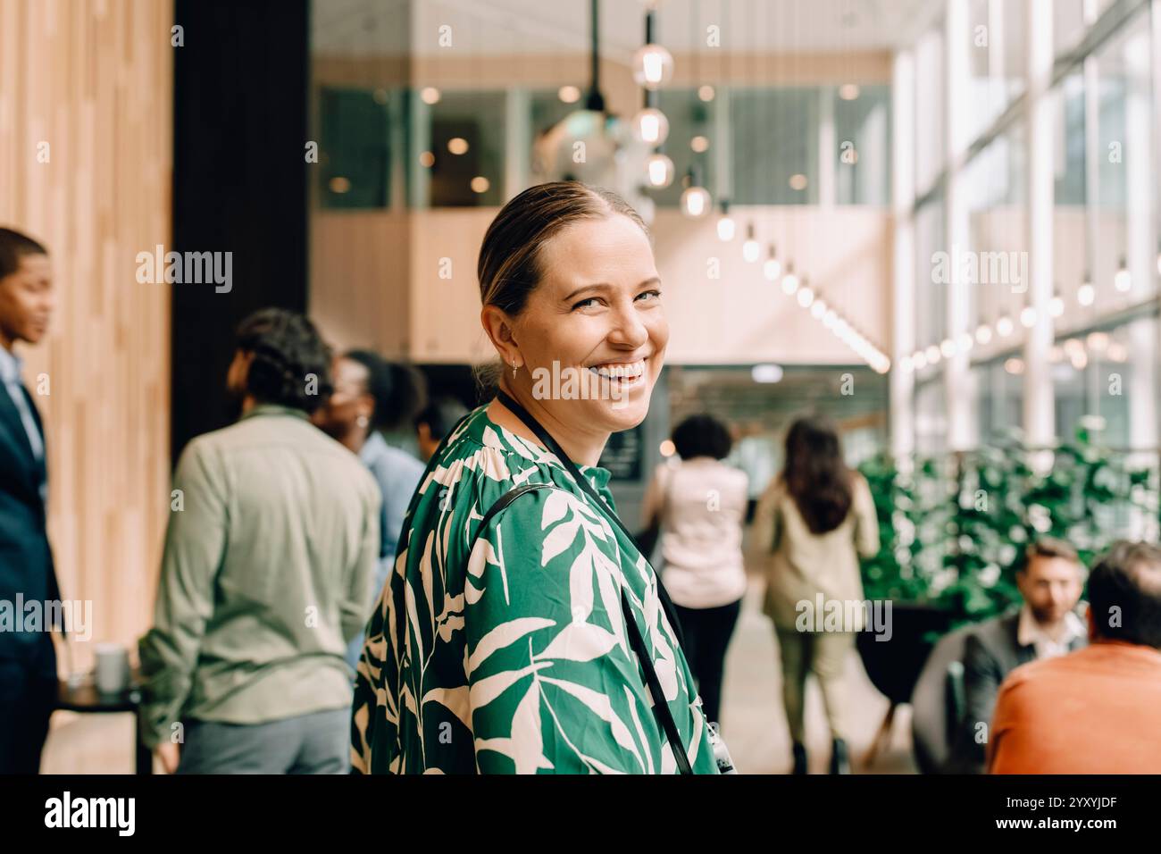 Seitenporträt einer glücklichen Unternehmerin, die während des Seminars im Kongresszentrum über die Schulter schaut Stockfoto