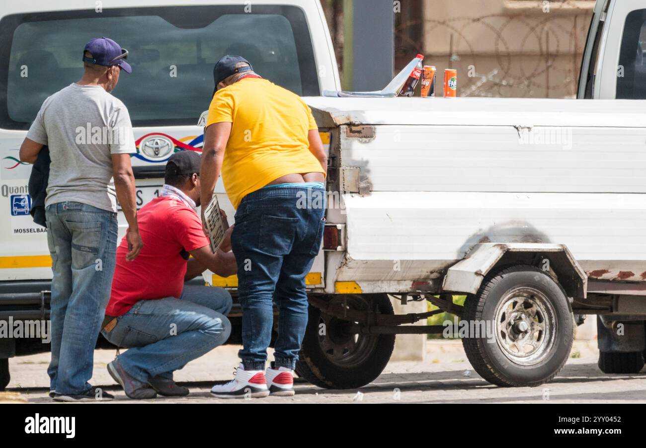 Eine kleine Gruppe afrikanischer Männer um ein Fahrzeug, das versucht, einen Anhänger für Fernreisen in Südafrika anzuhängen Stockfoto
