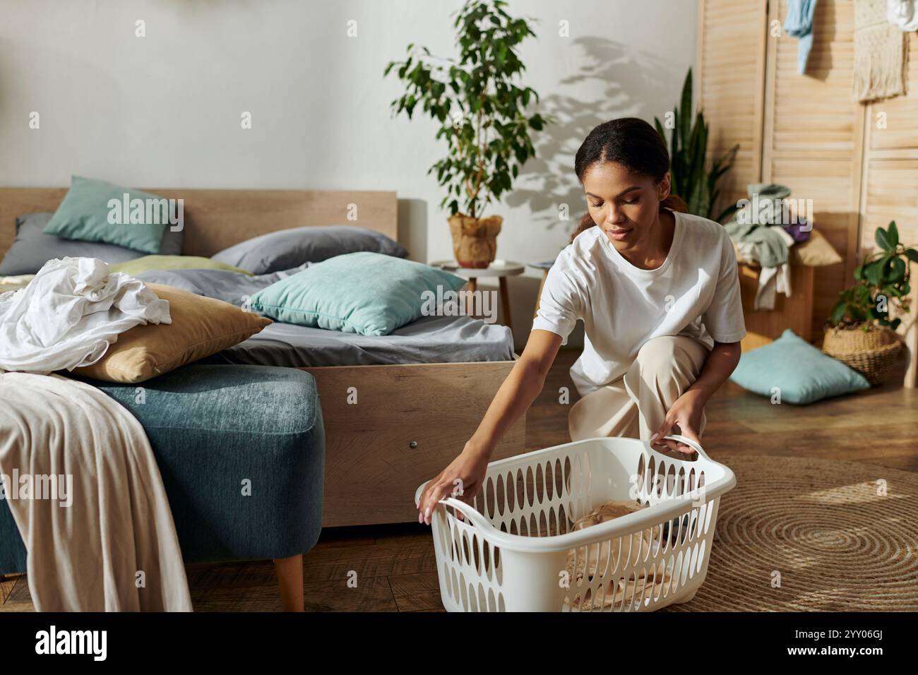 Heller und luftiger Raum, in dem eine junge Frau Wäsche organisiert und eine saubere Atmosphäre genießt. Stockfoto