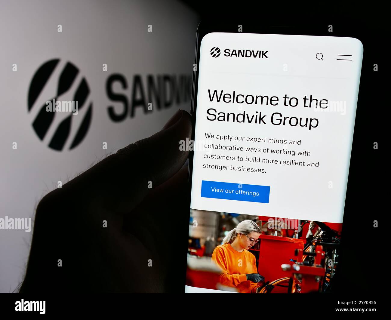Deutschland. August 2024. In dieser Abbildung hält eine Person ein Smartphone mit der Webseite des schwedischen Ingenieurunternehmens Sandvik ab vor dem Firmenlogo. (Foto von Timon Schneider/SOPA Images/SIPA USA) *** ausschließlich für redaktionelle Nachrichten *** Credit: SIPA USA/Alamy Live News Stockfoto