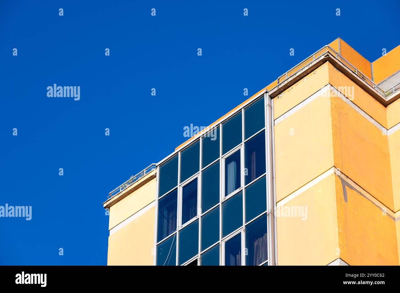 Detail eines gelben Apartmentblocks mit Balkonen in Tirana, Albanien, 7. Dezember 2024 Stockfoto