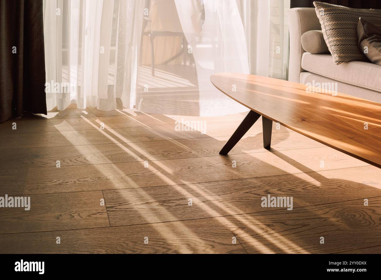 Moderne Innenausstattung mit offenem Fenster in minimalem Stil. Transparenter Tüll mit Morgensonnenstrahlen auf Schattenhintergrund. Hochwertige Fotos Stockfoto