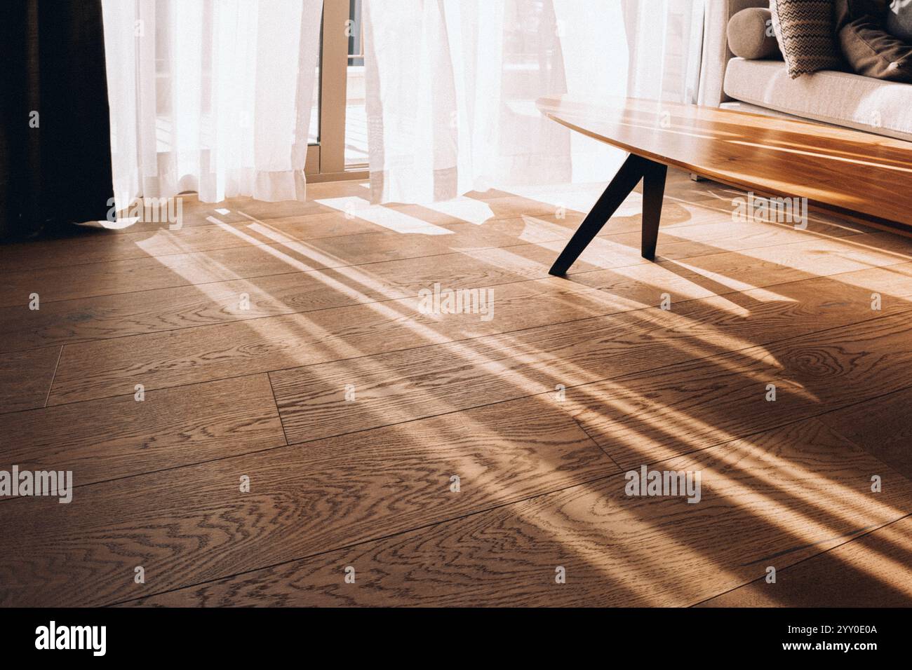 Moderne Innenausstattung mit offenem Fenster in minimalem Stil. Transparenter Tüll mit Morgensonnenstrahlen auf Schattenhintergrund. Hochwertige Fotos Stockfoto