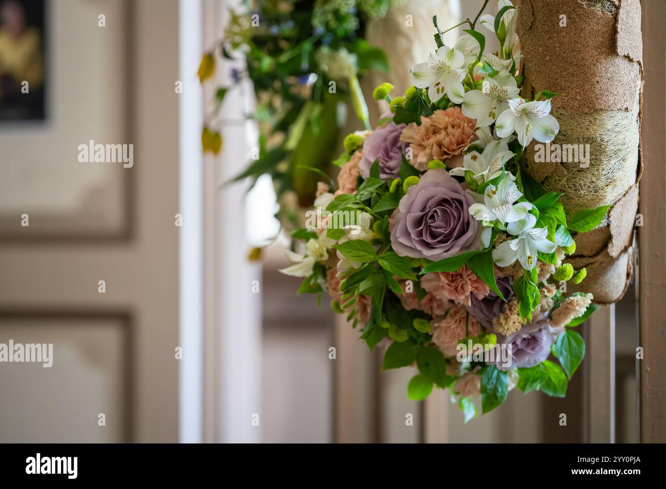 Ein Detail eines Blumenarrangements mit pastellfarbenen Blumen. Das Arrangement besteht aus einer zarten, violetten Rose und zarten, alten rosa Nelken. Stockfoto