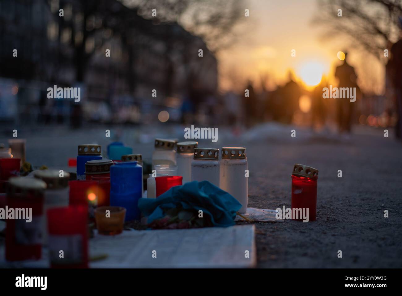 Kerzen und Laternen auf Asphalt zum Gedenken an den Verstorbenen, was eine feierliche und emotionale Hommage schafft Stockfoto