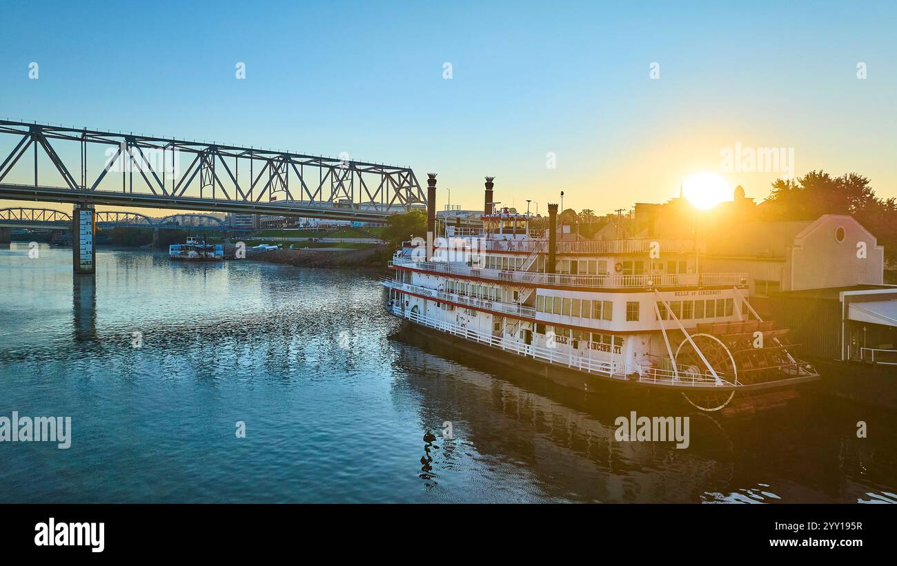 Luftaufnahme des Belle of Cincinnati Riverboat bei Sonnenaufgang mit Bridge Hintergrund Stockfoto