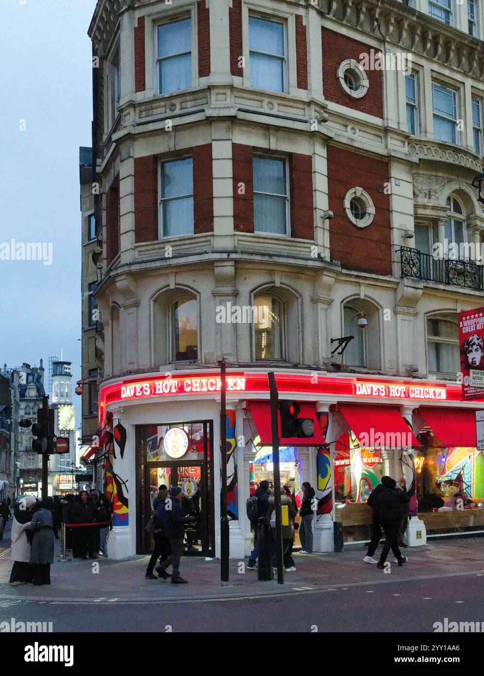 Lange Warteschlangen für Dave's Hot Chicken Restaurant auf der Shaftsbury Avenue in London vor Weihnachten Stockfoto