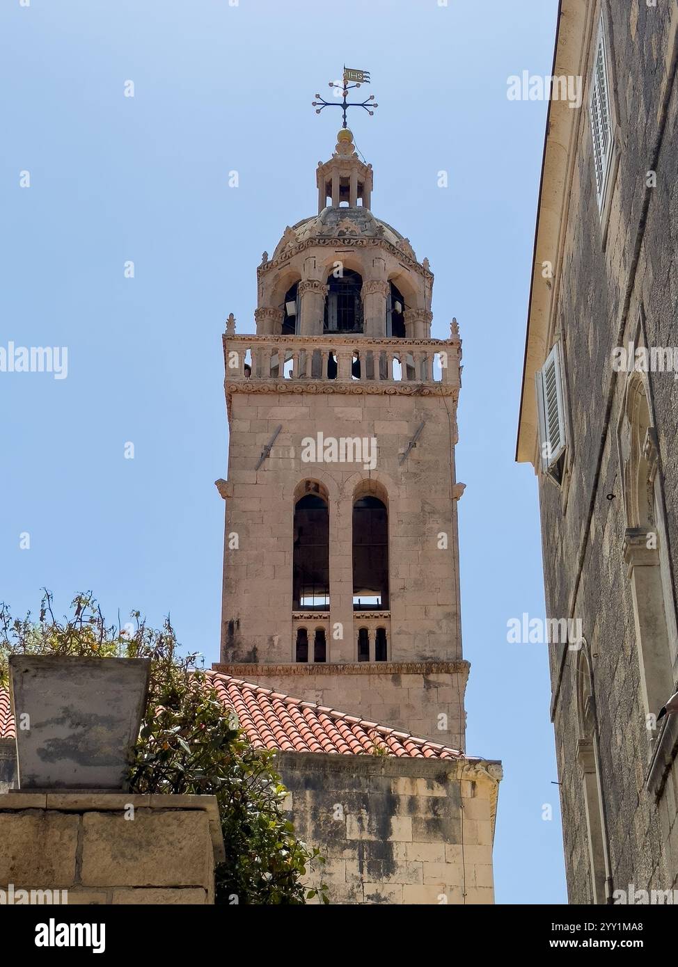 Korcula, Kroatien - 30. Juni 2024: Turm der Markuskirche aus gelbem Stein vor blauem Himmel Stockfoto