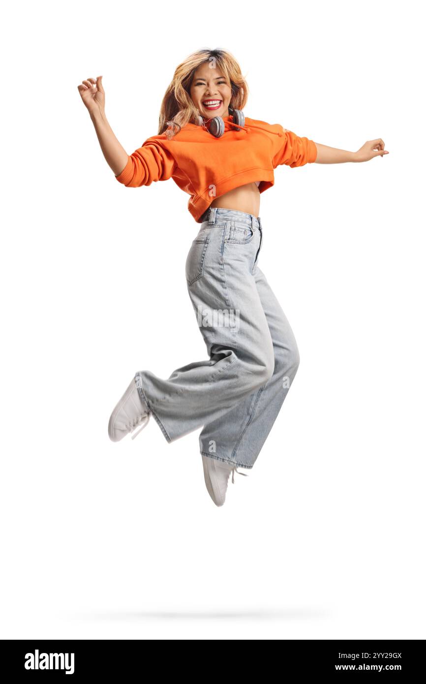 Überglückte asiatische Frau, die isoliert auf weißem Hintergrund springt Stockfoto