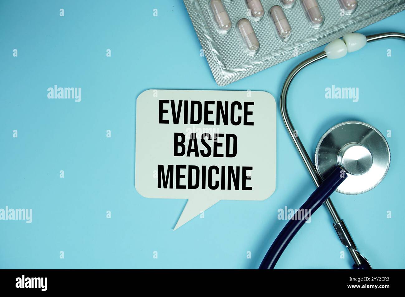 Evidenzbasierter Medizinstext mit Stethoskop und Kapselmedizin auf blauem Hintergrund, gesundes und Wellness-Konzept Stockfoto