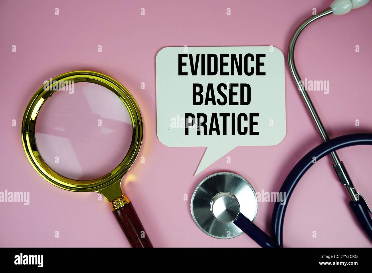 Evidenzbasierter Pratice Text mit Stethoskop und Lupe auf rosa Hintergrund, Gesundheits- und Wellness-Konzept Stockfoto