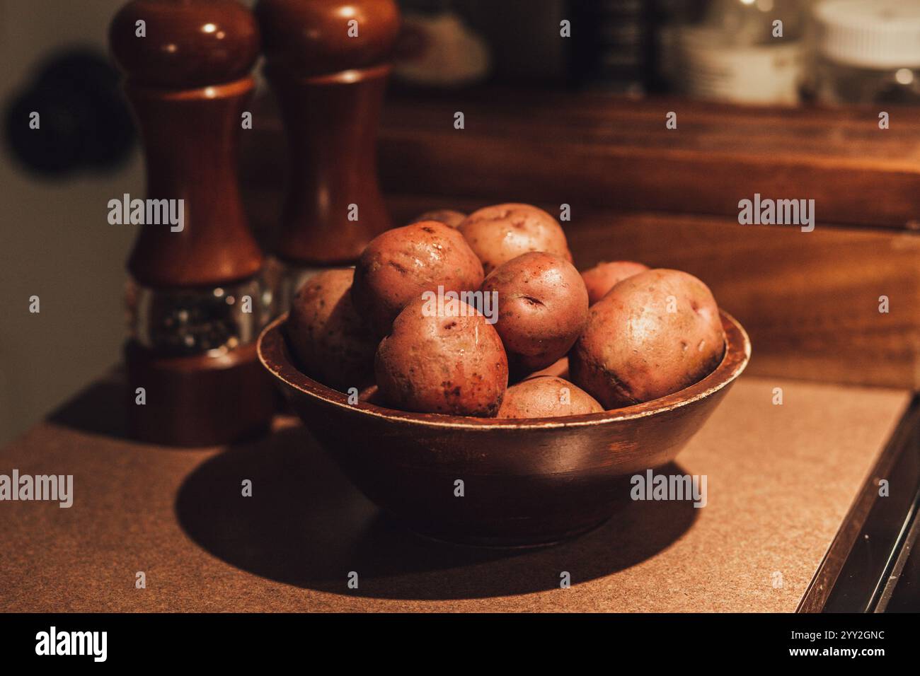 Rohe Kartoffeln mit Salz- und Pfefferstreuer Stockfoto