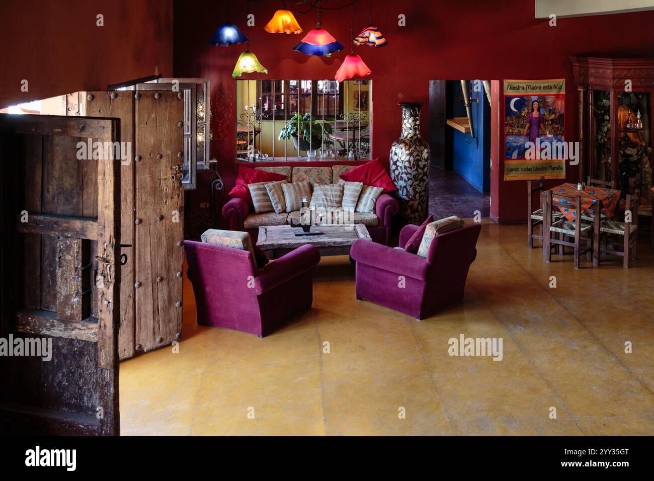 Ein Wohnzimmer mit einer Couch, Stühlen und einer Vase. Das Zimmer hat eine warme und einladende Atmosphäre Stockfoto