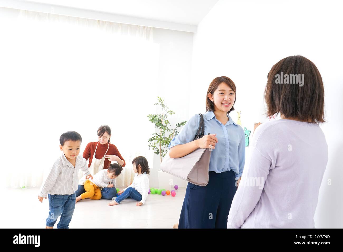 Geschäftsfrau, die ein Kind in den Kindergarten bringt Stockfoto