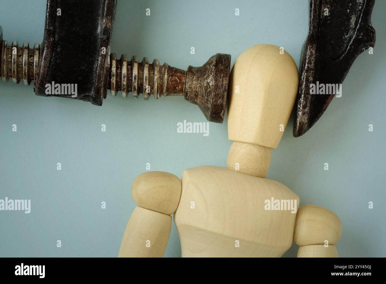 Hölzerne Schaufensterpuppe in eisernem Schraubstock - Konzept von Heachache, Stress und psychologischem Druck Stockfoto